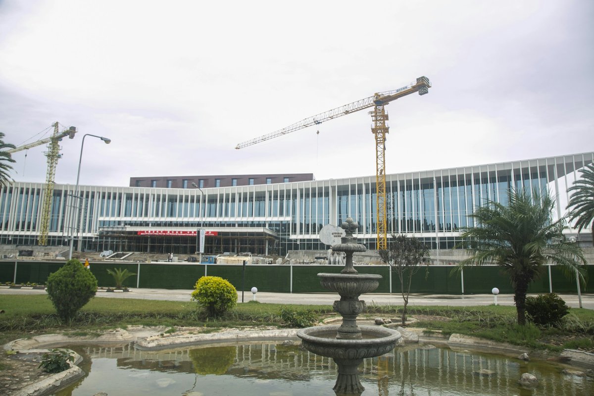 Grand bâtiment moderne en construction à Lusaka, grues au-dessus d'un bassin
