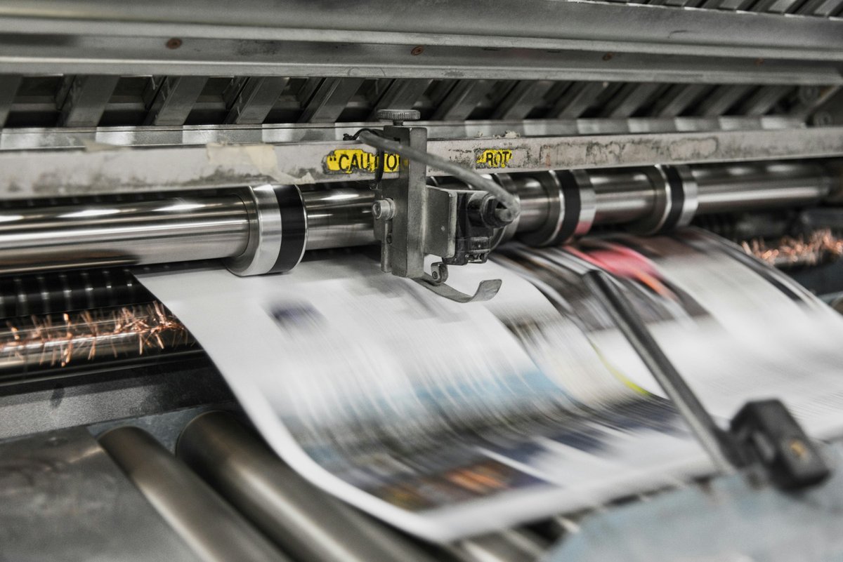 Rotative d'imprimerie, journaux imprimés défilant en sortie de machine